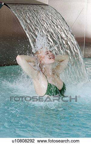 Young woman standing under water spray in spa pool View Large Photo Image Stock Image - Young woman standing under water spray in spa pool. Fotosearch