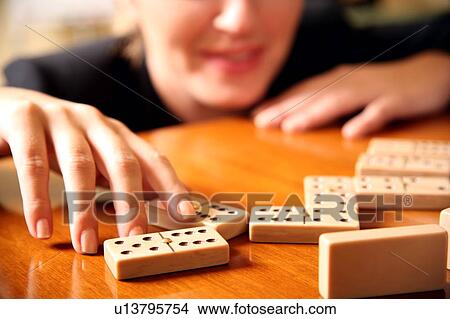 Picture - A woman playing with dominoes. Fotosearch