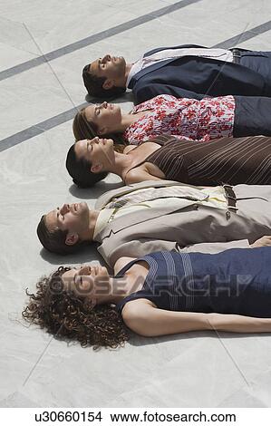 Business people lying on the ground in a row View Large Photo Image Picture - Business people lying on the ground in a row. Fotosearch