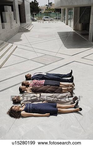Stock Photo - Business people lying on the ground in a row. Fotosearch
