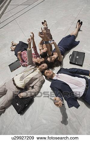 Stock Photo - Business people lying on the ground. Fotosearch