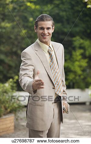 Stock Photo - Businessman in garden ready to handshake. Fotosearch