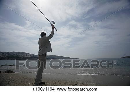 Businessman on beach fishing View Large Photo Image Picture - Businessman on beach fishing. Fotosearch