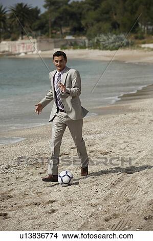 Businessman on beach playing soccer View Large Photo Image Picture - Businessman on beach playing soccer. Fotosearch
