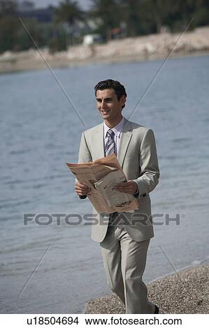 Picture - Businessman on beach with a newspaper. Fotosearch
