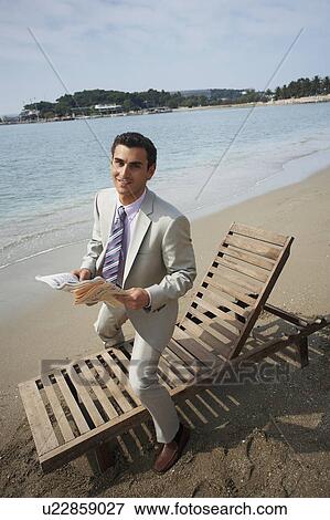 Stock Photo - Businessman on beach with a newspaper. Fotosearch