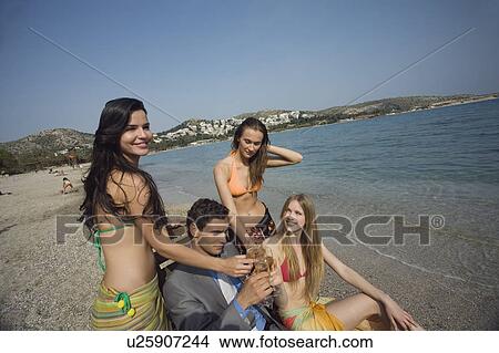 Businessman on beach with three women View Large Photo Image Picture - Businessman on beach with three women. Fotosearch
