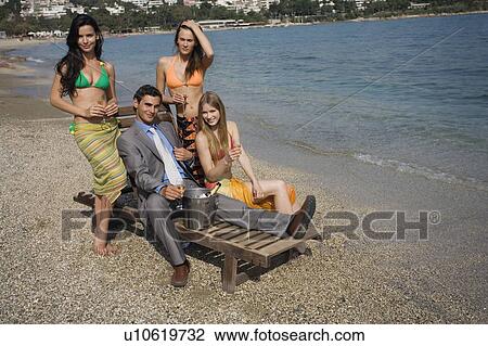 Businessman on beach with three women View Large Photo Image Stock Image - Businessman on beach with three women. Fotosearch