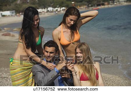 Businessman on beach with three women View Large Photo Image Stock Image - Businessman on beach with three women. Fotosearch