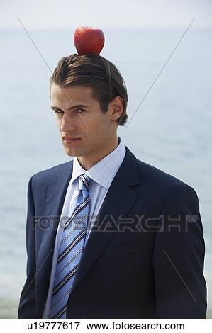 Businessman with apple balanced on his head View Large Photo Image Stock Photo - Businessman with apple balanced on his head. Fotosearch