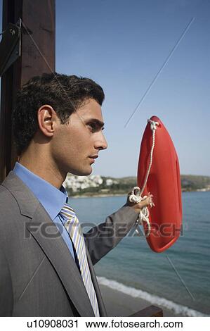 Stock Image - Businessman with life preserver. Fotosearch