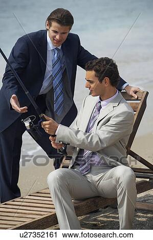 Stock Image - Businessmen on beach fishing. Fotosearch