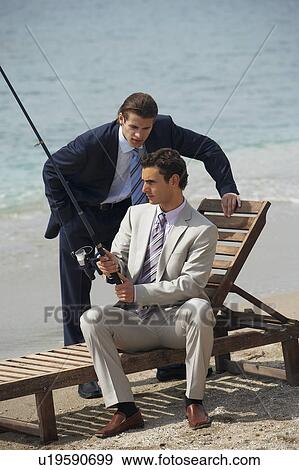 Stock Photo - Businessmen on beach fishing. Fotosearch