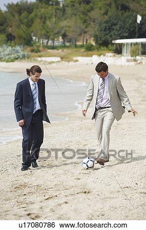 Businessmen on beach playing soccer View Large Photo Image Stock Photograph - Businessmen on beach playing soccer. Fotosearch