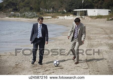 Businessmen on beach playing soccer View Large Photo Image Stock Photograph - Businessmen on beach playing soccer. Fotosearch