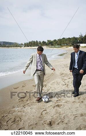 Businessmen on beach playing soccer View Large Photo Image Stock Photography - Businessmen on beach playing soccer. Fotosearch