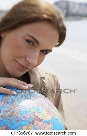 Stock Photo - Businesswoman on beach with globe. Fotosearch