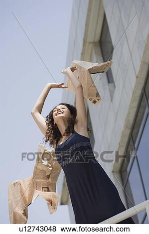 Stock Photo - Happy businesswoman throwing newspaper in the air. Fotosearch