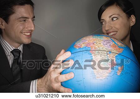 Male and female businesspeople with globe View Large Photo Image Stock Image - Male and female businesspeople with globe. Fotosearch