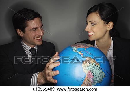 Male and female businesspeople with globe View Large Photo Image Stock Photo - Male and female businesspeople with globe. Fotosearch