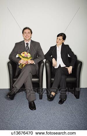 Male office worker with flowers sitting next to female colleague View Large Photo Image Stock Image - Male office worker with flowers sitting next to female colleague. Fotosearch