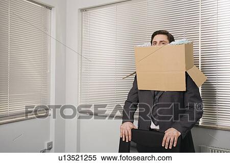 Stock Photography - Office worker with head in a box. Fotosearch