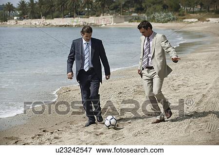 Businessmen on beach playing soccer View Large Photo Image Stock Photo - Businessmen on beach playing soccer. Fotosearch