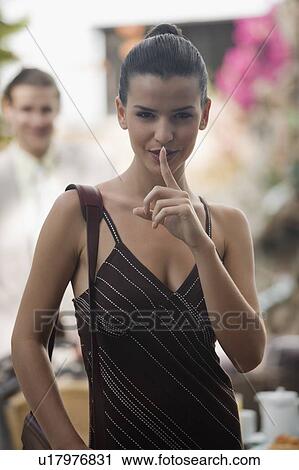 Stock Image - Businesswoman in garden with businessman in background. Fotosearch