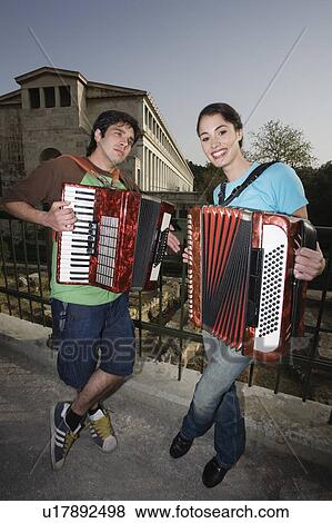 Stock Photo - Couple at archaeological site playing accordion. Fotosearch