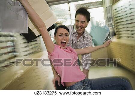 Happy couple posing with shopping bags in a sunglasses store View Large Photo Image Stock Photography - Happy couple posing with shopping bags in a sunglasses store. Fotosearch