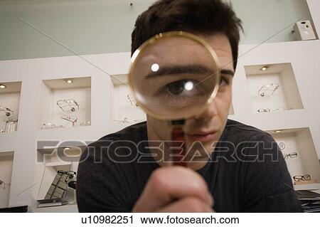 Man with magnifying glass on eye View Large Photo Image Stock Image - Man with magnifying glass on eye. Fotosearch