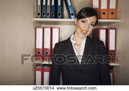 Office worker with pencil in her mouth View Large Photo Image Picture - Office worker with pencil in her mouth. Fotosearch
