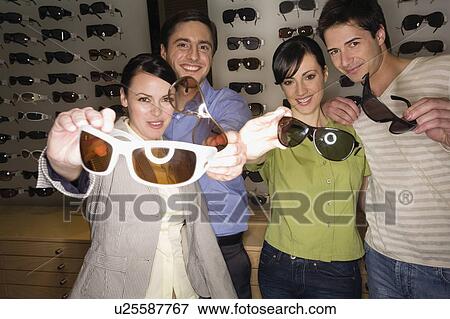 Two couples posing with sunglasses in store View Large Photo Image Stock Photo - Two couples posing with sunglasses in store. Fotosearch