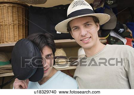 Stock Image - Two men shopping for hats. Fotosearch