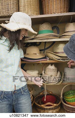 Stock Photo - Woman shopping for hats. Fotosearch