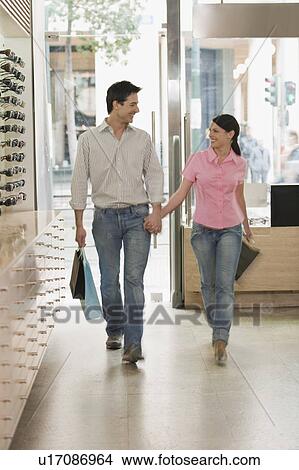 Couple entering sunglasses store View Large Photo Image Picture - Couple entering sunglasses store. Fotosearch