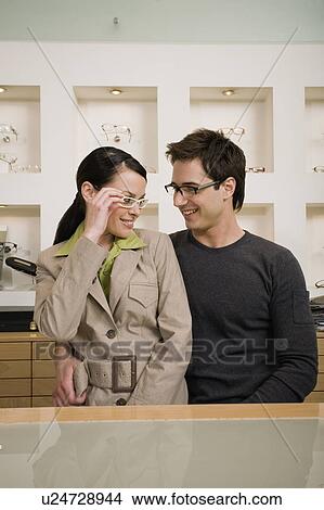 Couple posing with eyeglasses in store View Large Photo Image Picture - Couple posing with eyeglasses in store. Fotosearch