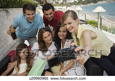 Stock Photography - Group of friends with shopping bags taking photo. Fotosearch