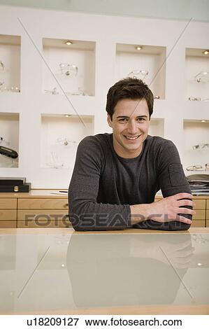 Stock Photo - Man in eyeglass store. Fotosearch