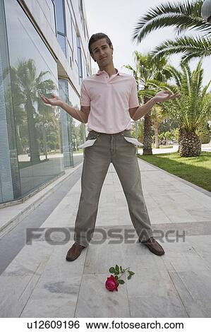Man with pockets turned out and rose on the ground View Large Photo Image Stock Photograph - Man with pockets turned out and rose on the ground. Fotosearch