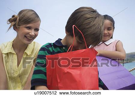 Mother and two children with shopping bags View Large Photo Image Stock Image - Mother and two children with shopping bags. Fotosearch