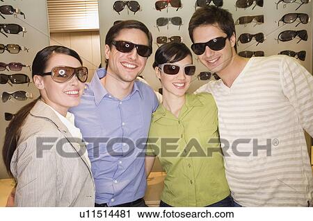 Two couples posing with sunglasses in store View Large Photo Image Stock Image - Two couples posing with sunglasses in store. Fotosearch