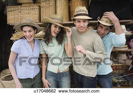 Stock Image - Two couples shopping for hats. Fotosearch