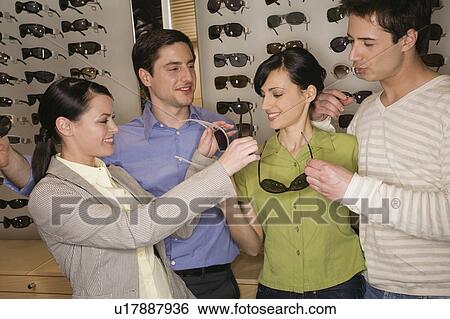 Two couples shopping for sunglasses in store View Large Photo Image Stock Photograph - Two couples shopping for sunglasses in store. Fotosearch
