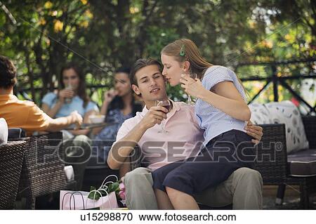 Woman sitting on man's lap with shopping bags in cafe View Large Photo Image Stock Image - Woman sitting on man's lap with shopping bags in cafe. Fotosearch