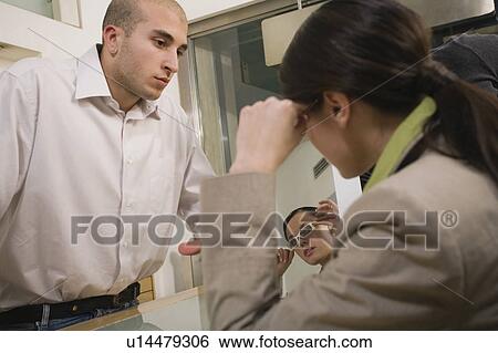 Stock Photograph - Woman trying on glasses in store. Fotosearch