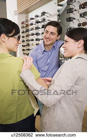 Woman trying on sunglasses in store View Large Photo Image Stock Image - Woman trying on sunglasses in store. Fotosearch
