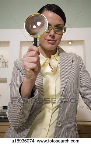 Picture - Woman with magnifying glass in store. Fotosearch