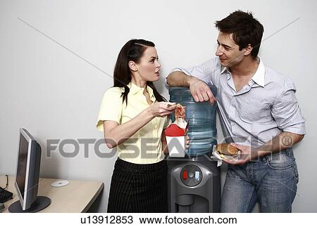 Stock Image - Male and female office workers eating take out food. Fotosearch