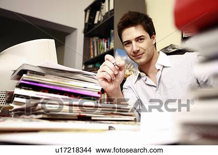 Male office worker at cluttered desk View Large Photo Image Picture - Male office worker at cluttered desk. Fotosearch
